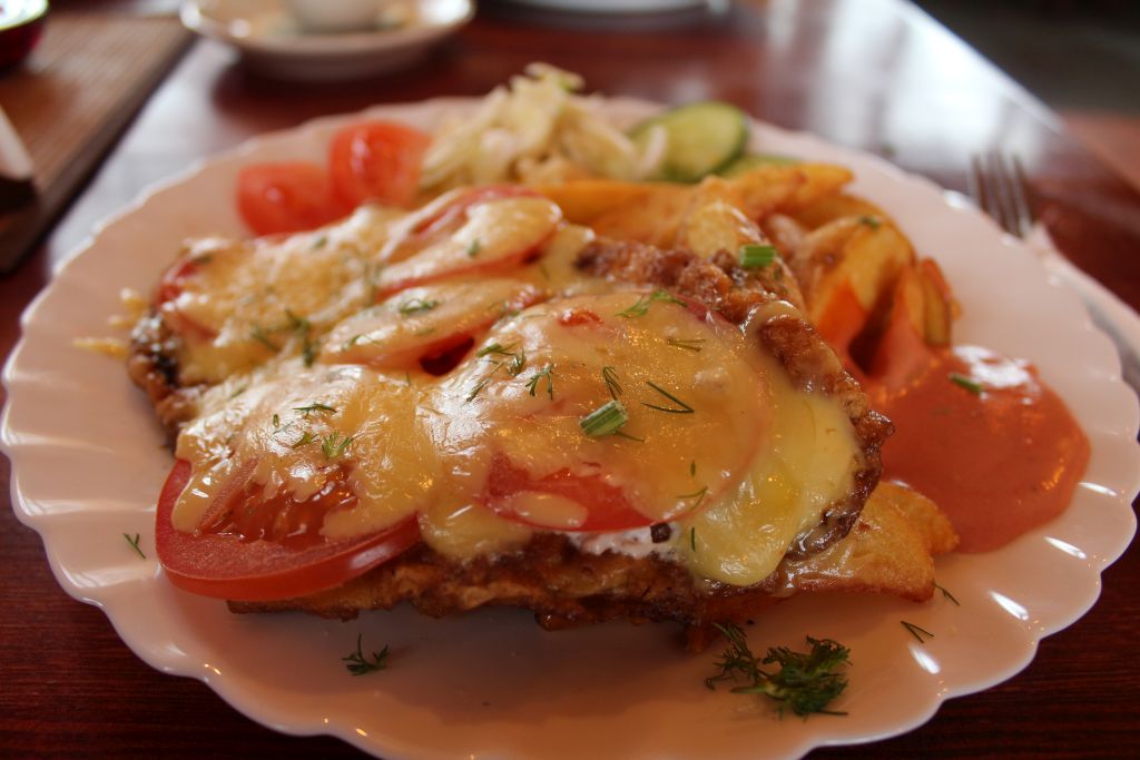 Chop dressed with cheese and tomatoes and served with potatoes