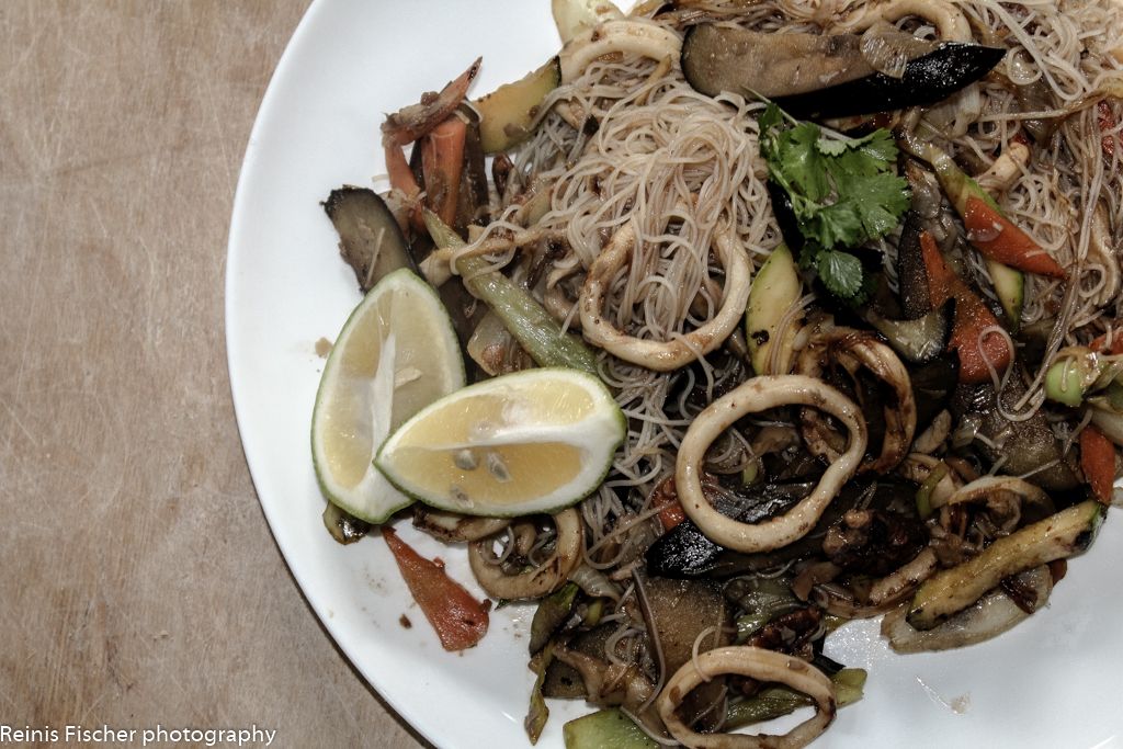 Asian Cuisine - Rice noodles, fried vegetables and a squid