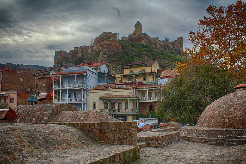 Public bath houses, colorful balconies and Narikala fortress on top