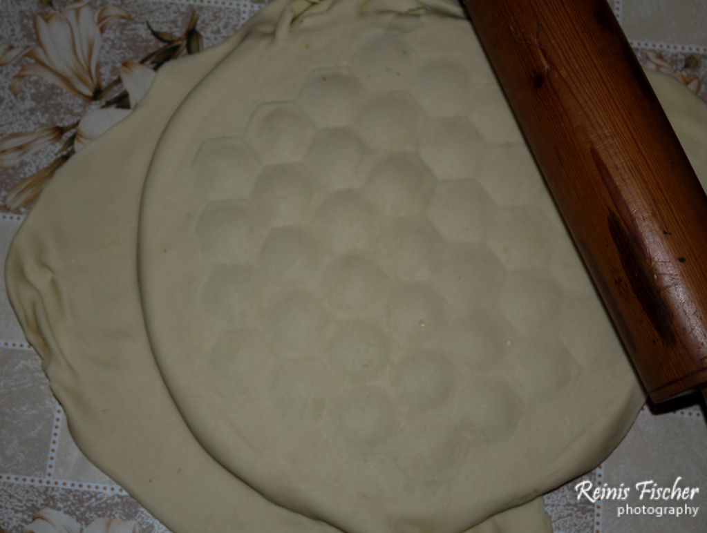 Adding second layer of flattened dough and using rolling pin to stick them together