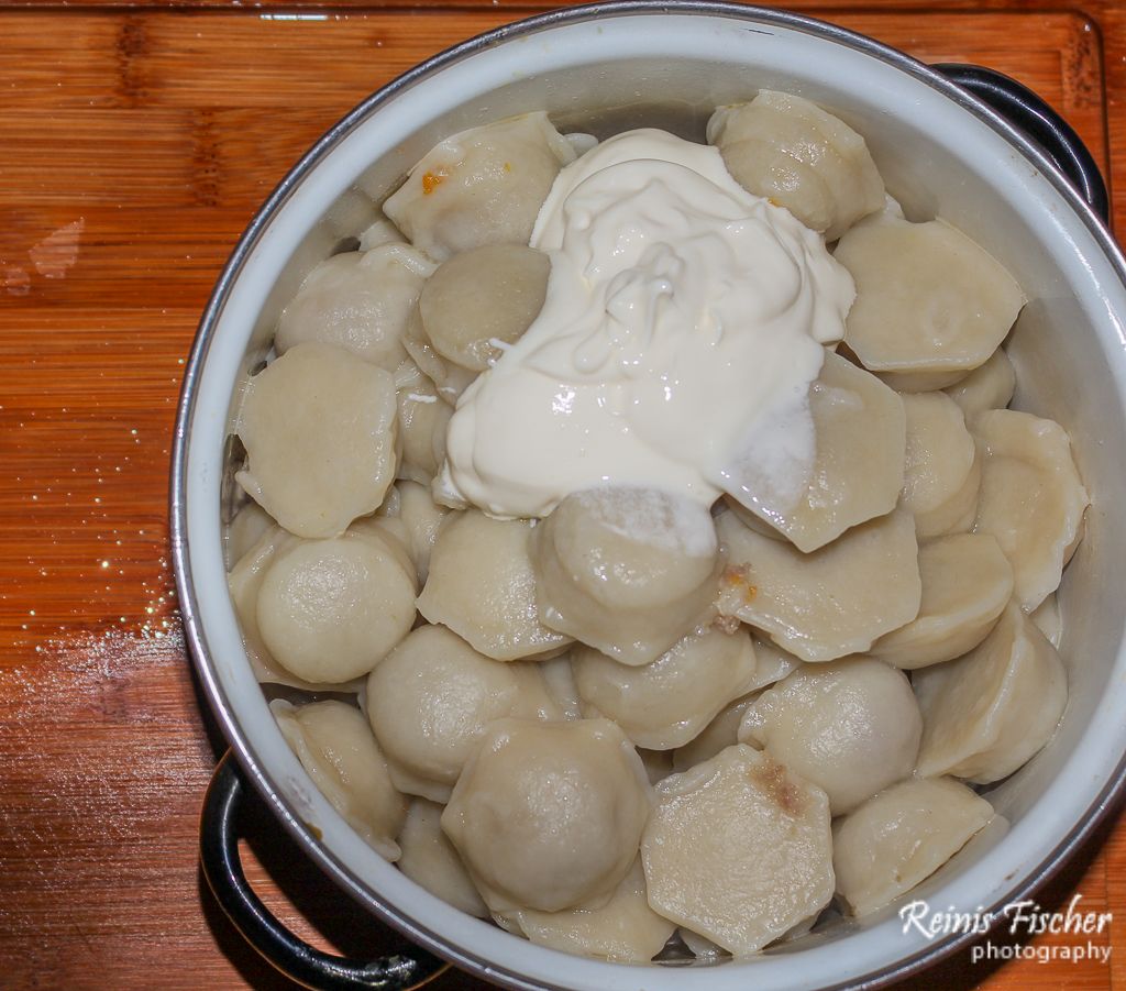 Boiled dumplings served with sour cream