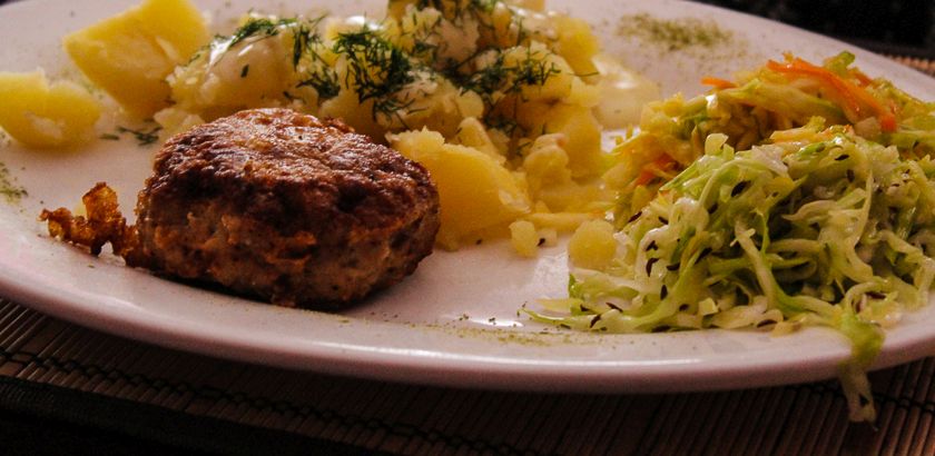 Meat balls with boiled potatoes as side dish and cabbage saldads