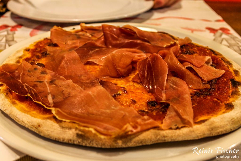 Four formage pizza topped with a lot of prosciutto 